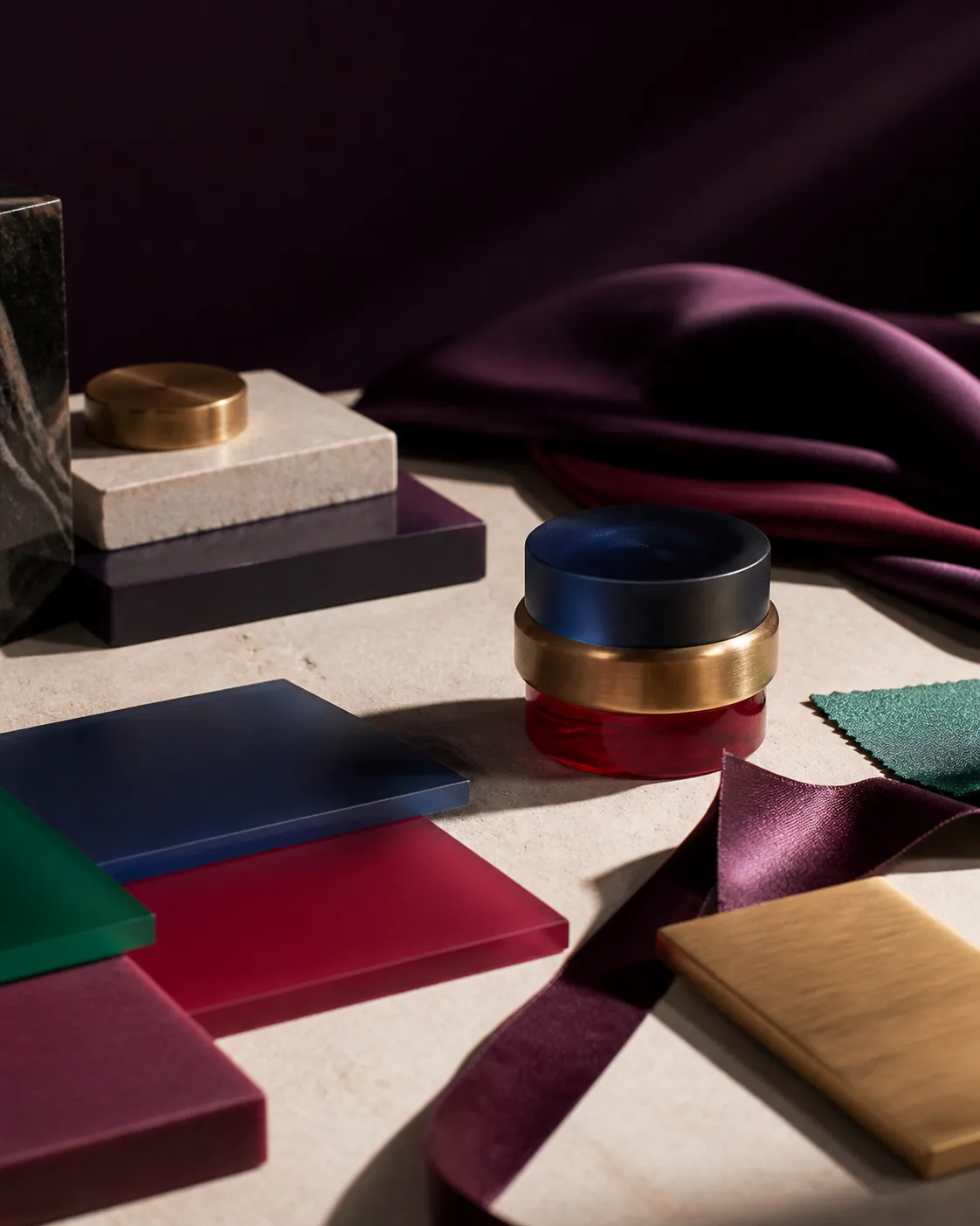 Pre-launch concept image of the jewel-toned translucent, warm brass, matte and ribbon material palette